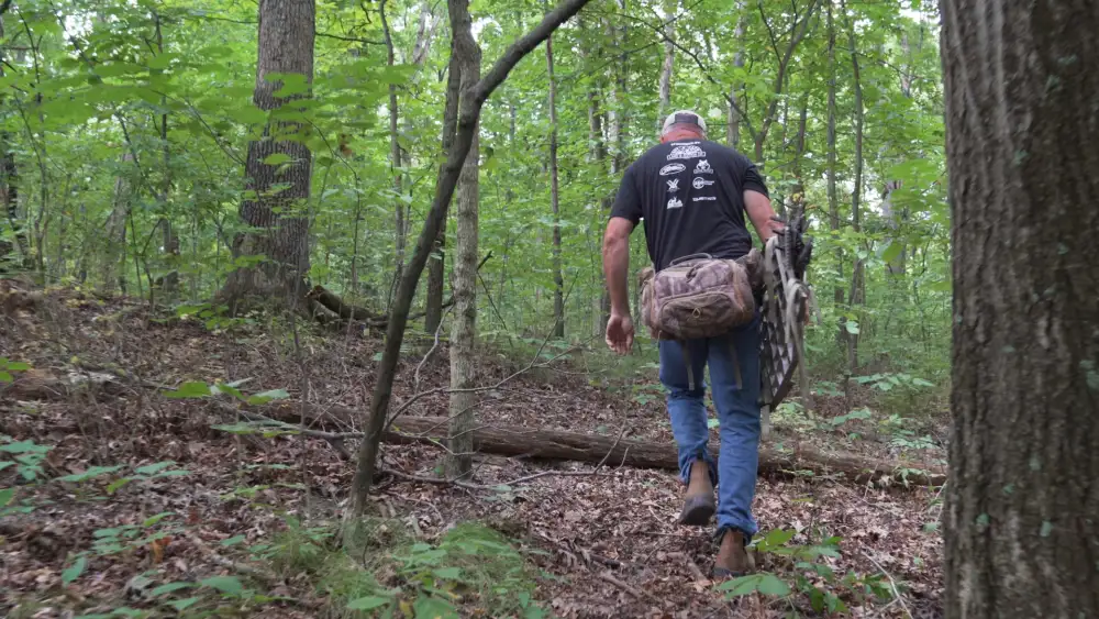 Hunter walking into the timber to scout a hunting property